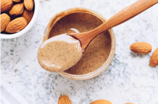 a jar of almond butter with a spoon